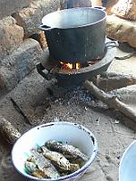 Senegal complet 142 Le poisson est séché, pour qu'il puisse se conserver. Ici, pas de frigo. Le petit trépied avec une seule entrée de bois permet de diviser par 3 la consommation...
